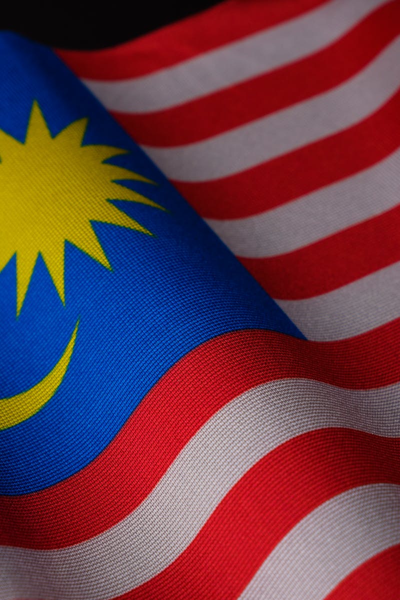 A detailed close-up of the Malaysian flag showing its vibrant colors and waving fabric texture.